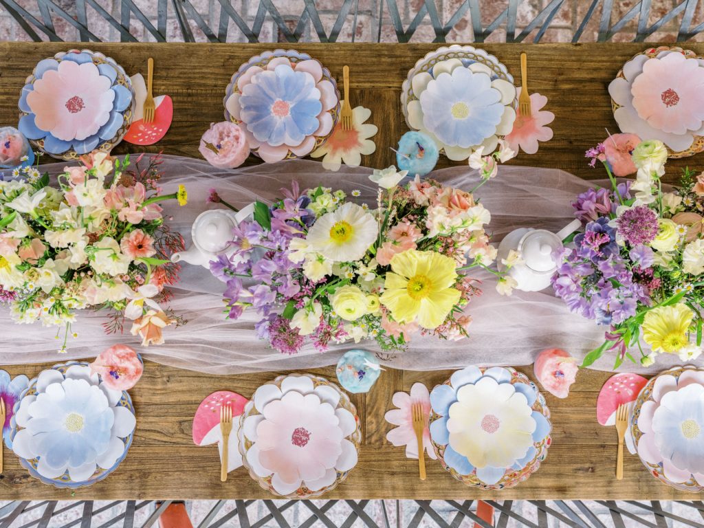 Yellow and purple flower arrangements on a table with flower plates